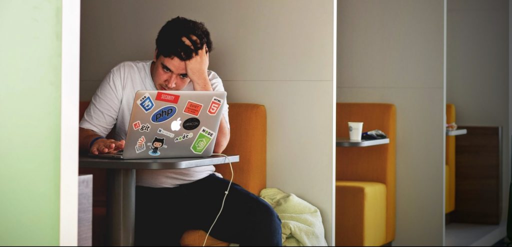 man wearing white top using MacBook
